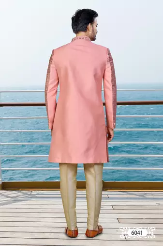 Peach sherwani with woven detailing and gold-toned trousers—perfect for weddings and celebrations.
