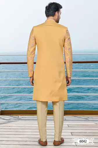 Mustard sherwani with pink and gold floral embroidery—perfect for festive weddings.
