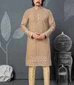 Beige kurta with colorful embroidery and gold pajama—perfect for weddings and festive occasions.