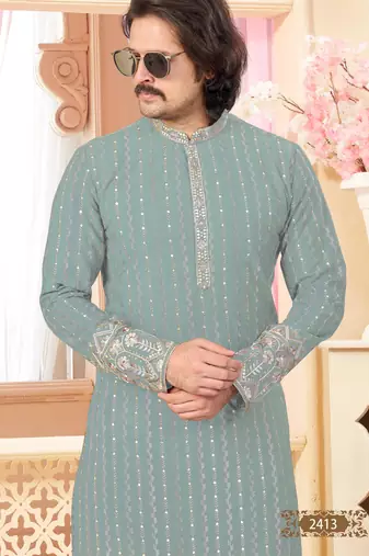 Sage green kurta with floral embroidery, paired with gold pajama—perfect for festive occasions.