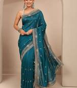 teal floral zari embroidered saree with zari embellished border and a blouse piece