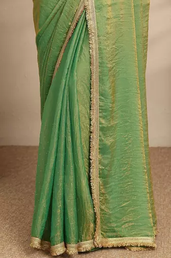 green beads embellished saree with zari embellished saree and a blouse piece
