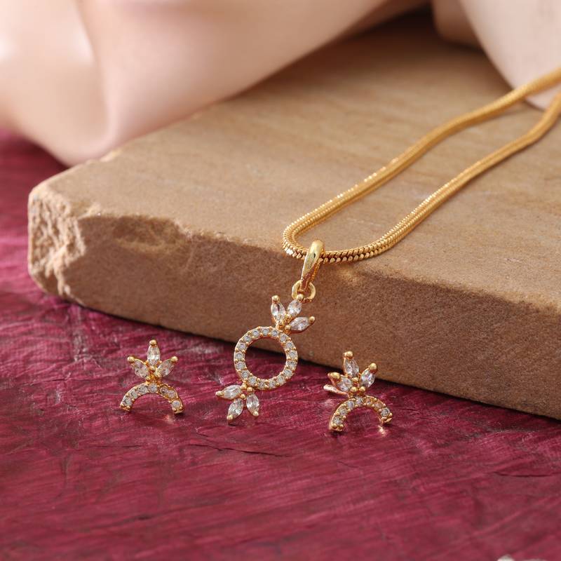Radiant sheen gold color american diamond pendant set designed for evening celebrations