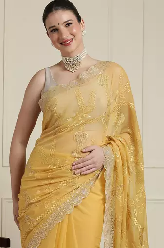Yellow ethnic motifs embroidered scallop zari border saree