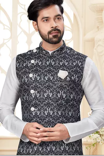 Maroon kurta and trousers paired with blue waistcoat featuring an intricate red pattern, gold-tone buttons