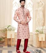 A soft peach kurta with scattered red floral motifs and striped detailing along the collar, placket, and cuffs