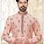 A soft peach kurta with scattered red floral motifs and striped detailing along the collar, placket, and cuffs