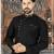 Black kurta with a subtle textured finish, featuring an asymmetrical line of gold-tone buttons.