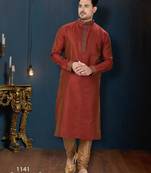 Rust-red kurta with a subtle all-over pattern and ornate gold-toned trim along the collar, placket and cuffs