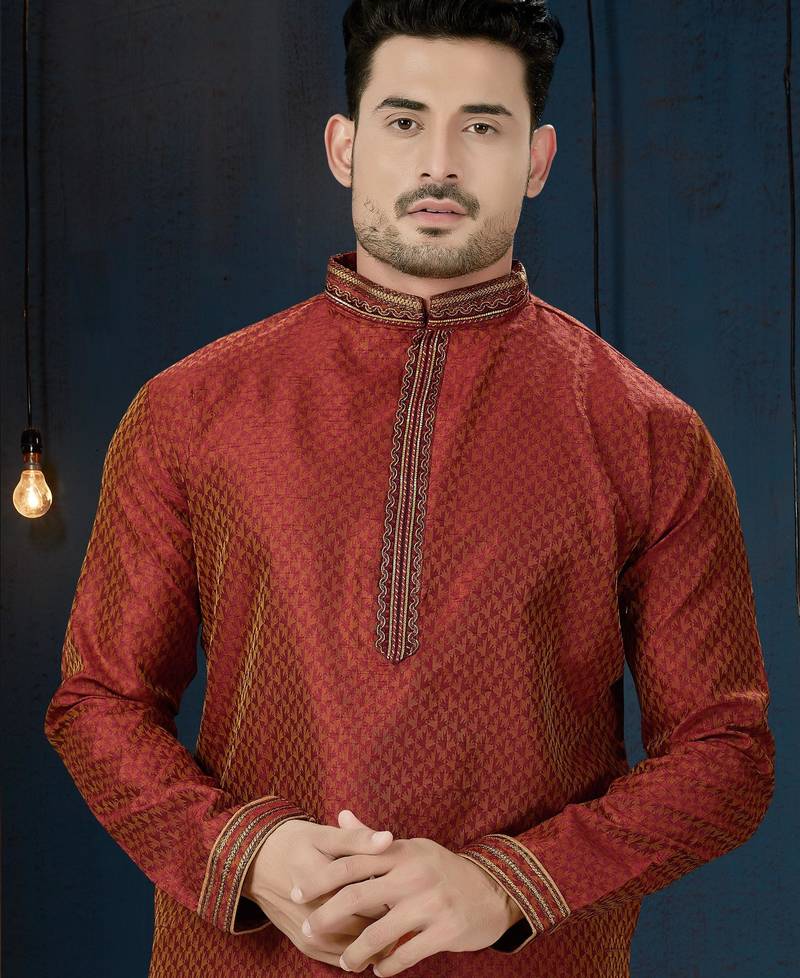 Rust-red kurta with a subtle all-over pattern and ornate gold-toned trim along the collar, placket and cuffs