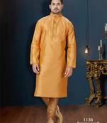 Mustard-gold kurta with a subtle tonal pattern and a contrasting gold placket, styled with matching trousers.