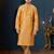 Mustard-gold kurta with a subtle tonal pattern and a contrasting gold placket, styled with matching trousers.
