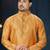 Mustard-gold kurta with a subtle tonal pattern and a contrasting gold placket, styled with matching trousers.