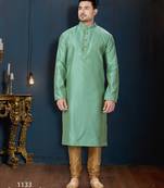 Sea-green kurta with an elegant tonal jacquard pattern, stand collar and gold-buttons, paired with gold trousers.