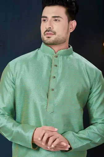 Sea-green kurta with an elegant tonal jacquard pattern, stand collar and gold-buttons, paired with gold trousers.
