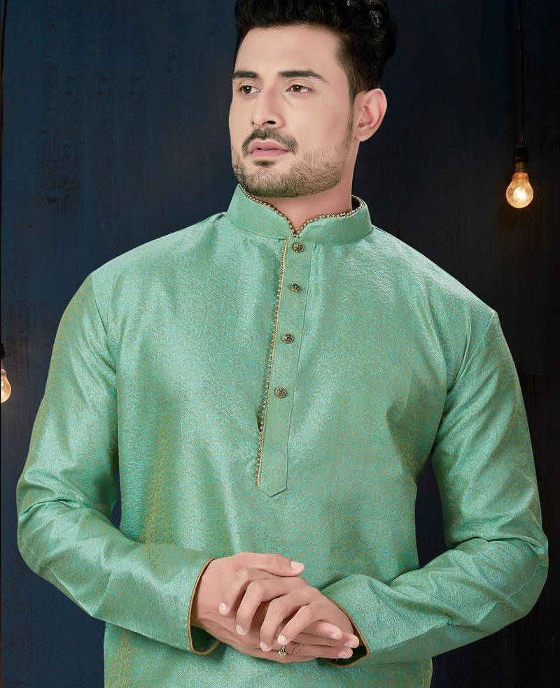 Sea-green kurta with an elegant tonal jacquard pattern, stand collar and gold-buttons, paired with gold trousers.