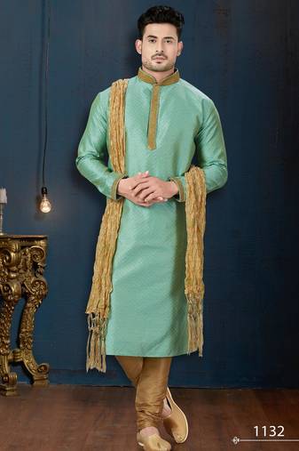 Mint-green kurta with a subtle woven pattern and gold-trimmed collar, placket and cuffs, paired with gold trousers.