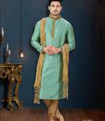 Mint-green kurta with a subtle woven pattern and gold-trimmed collar, placket and cuffs, paired with gold trousers.