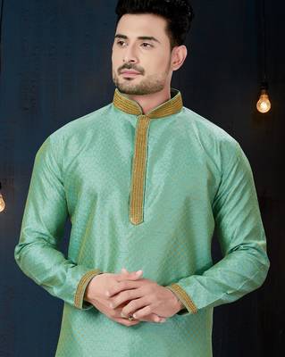 Mint-green kurta with a subtle woven pattern and gold-trimmed collar, placket and cuffs, paired with gold trousers. 2