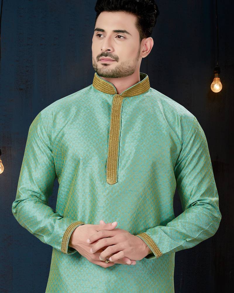 Mint-green kurta with a subtle woven pattern and gold-trimmed collar, placket and cuffs, paired with gold trousers.