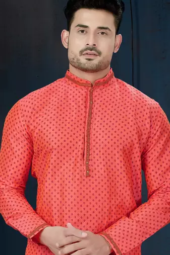 Coral-pink kurta with a subtle along the collar,placket and cuffs,paired with white trousers.