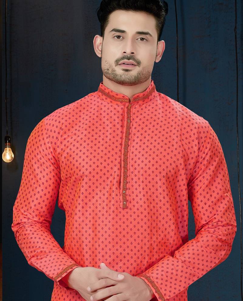 Coral-pink kurta with a subtle along the collar,placket and cuffs,paired with white trousers.