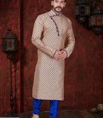 Peach kurta with blue motifs and an asymmetrical neckline, paired with royal-blue trousers— festive wear