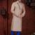 Peach kurta with blue motifs and an asymmetrical neckline, paired with royal-blue trousers— festive wear