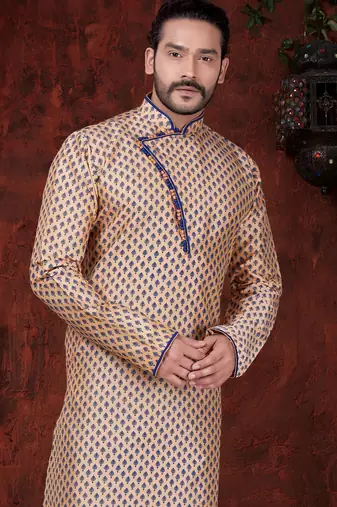 Peach kurta with blue motifs and an asymmetrical neckline, paired with royal-blue trousers— festive wear