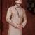 Peach kurta with blue motifs and an asymmetrical neckline, paired with royal-blue trousers— festive wear