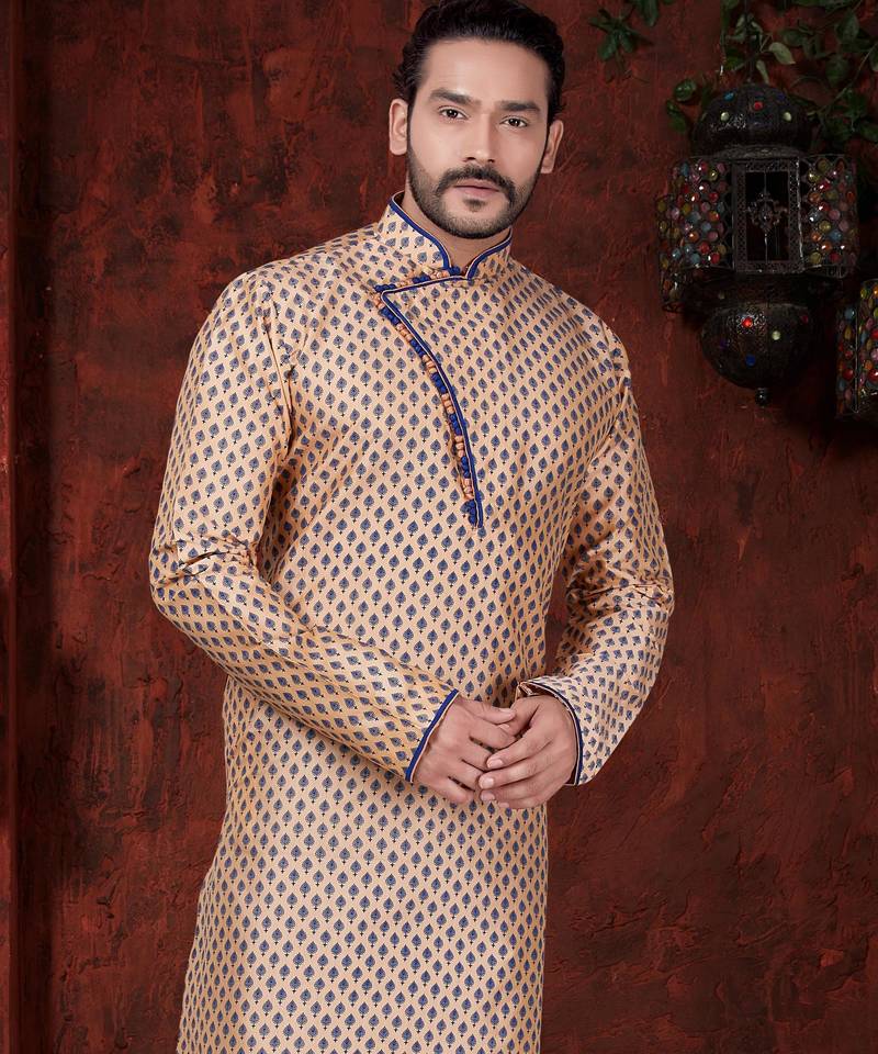 Peach kurta with blue motifs and an asymmetrical neckline, paired with royal-blue trousers— festive wear