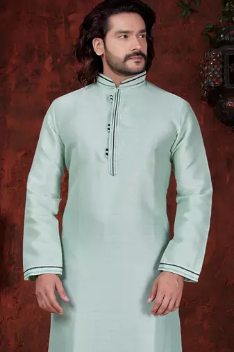 Mint-green kurta with subtle dark piping, paired with black trousers—clean, understated festive style.