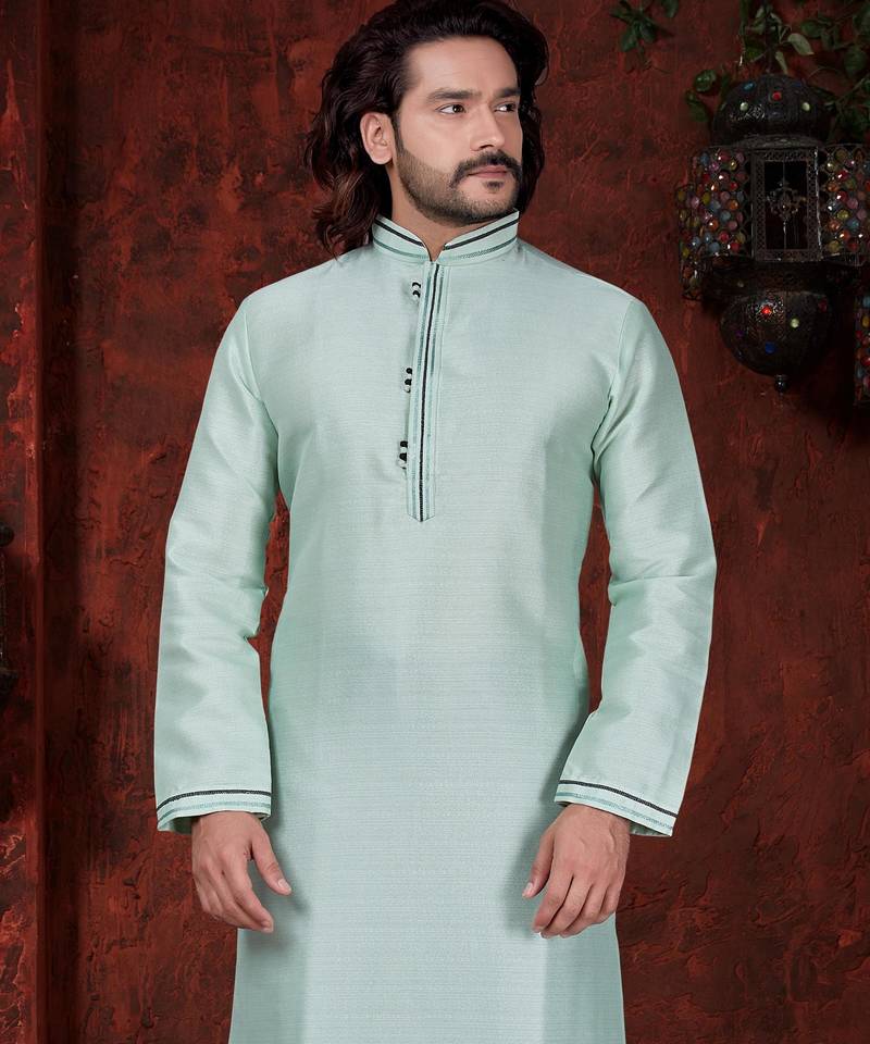 Mint-green kurta with subtle dark piping, paired with black trousers—clean, understated festive style.