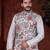 White kurta set with a richly patterned floral nehru jacket in red, blue, and gold—perfect for festive occasions.