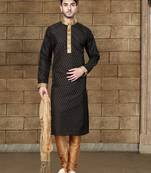 Black kurta with subtle gold motifs and gold-trimmed detailing, paired with brown trousers --an elegant festive wear