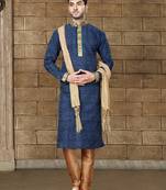 Navy patterned kurta with gold trim paired with brown trousers—an elegant festive ensemble.