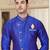 Royal-blue sherwani with gold motifs, asymmetrical front,—perfect for celebrations.