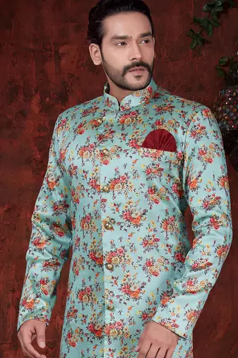 Aqua floral sherwani with gold buttons, maroon pocket square, and matching trousers.