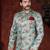 Aqua floral sherwani with gold buttons, maroon pocket square, and matching trousers.