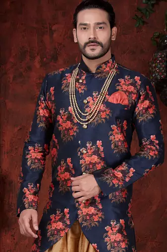 Navy blue floral sherwani with asymmetrical hem, pearl necklace, and gold trousers.