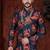 Navy blue floral sherwani with asymmetrical hem, pearl necklace, and gold trousers.