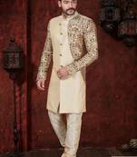 Fawn sherwani with floral sleeves, gold buttons, and matching trousers—ideal for weddings.