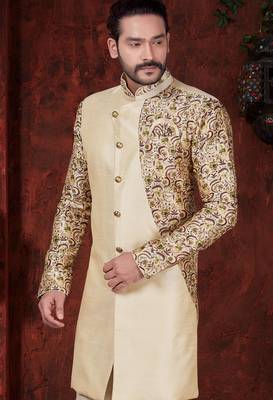 Fawn sherwani with floral sleeves, gold buttons, and matching trousers—ideal for weddings. 2