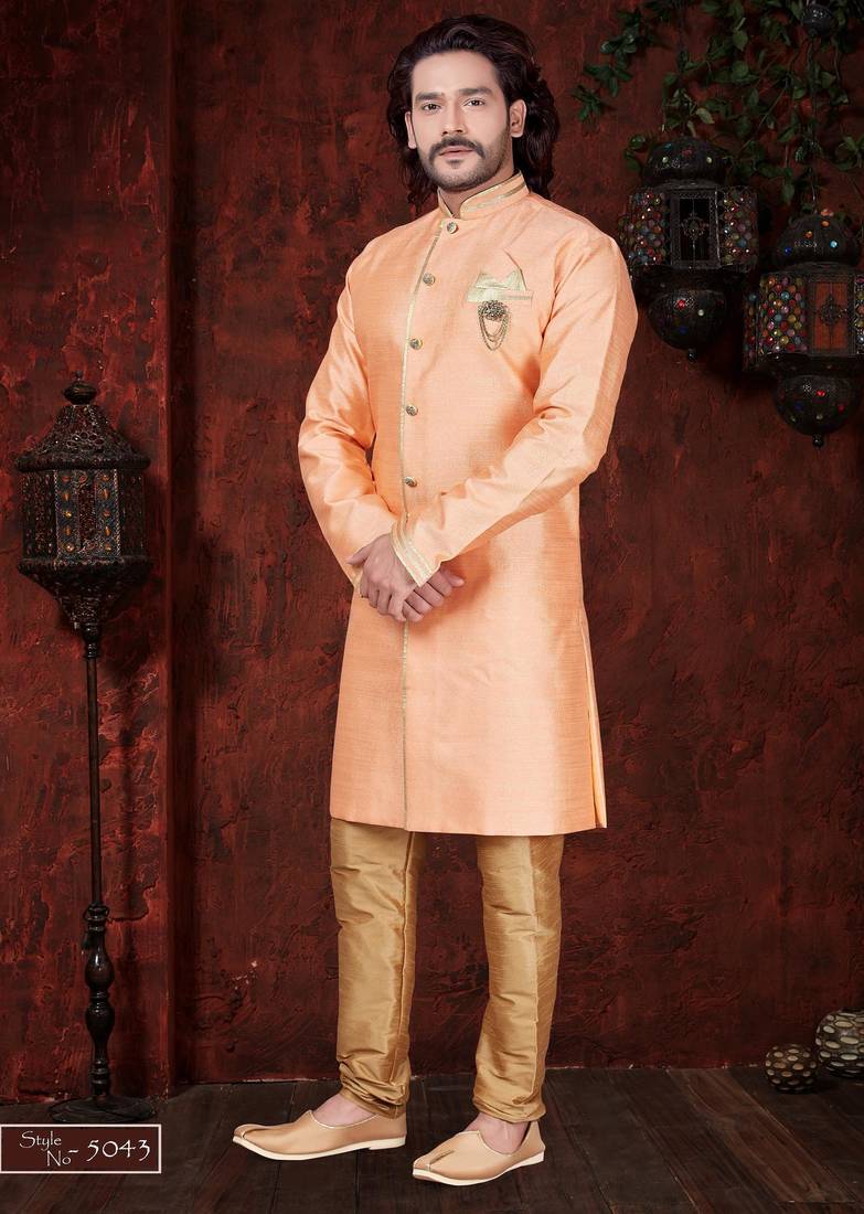 Peach sherwani with gold trim, ornate buttons, and matching pocket square.
