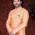 Peach sherwani with gold trim, ornate buttons, and matching pocket square.