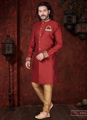 Maroon sherwani with gold trim, ornate buttons, and embroidered pocket square. 1