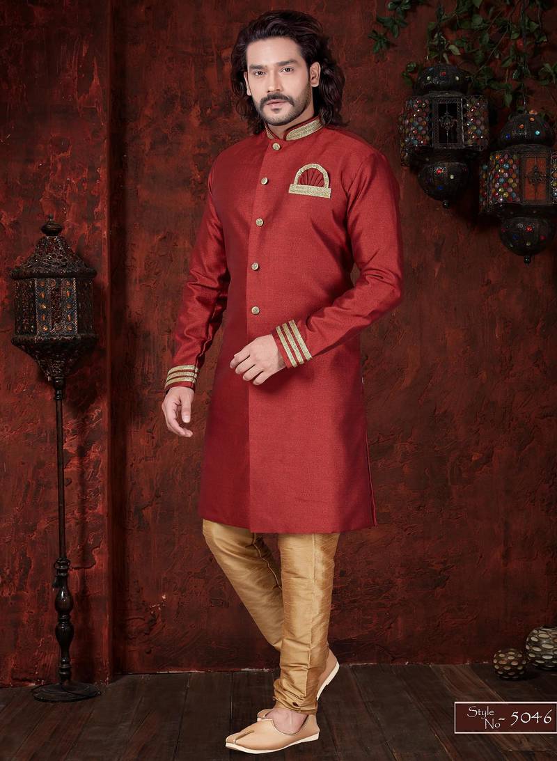Maroon sherwani with gold trim, ornate buttons, and embroidered pocket square.