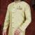 Light pistachio sherwani with gold-trimmed cuffs and collar, ornate buttons,& pocket square.