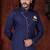 Navy-blue sherwani with asymmetrical placket, gold pocket square, and gold trousers.