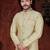 Fawn sherwani with gold motifs, matching pocket square, and gold trousers—ideal for weddings.